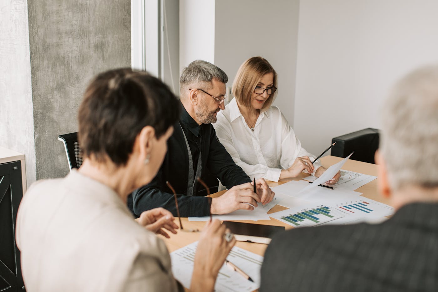Finance team reviewing detailed transaction documents in a meeting